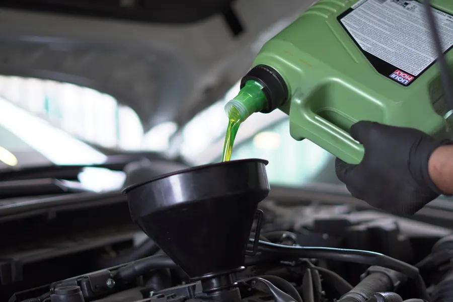 Carga de aceite de motor nuevo con embudo durante una mantención a domicilio