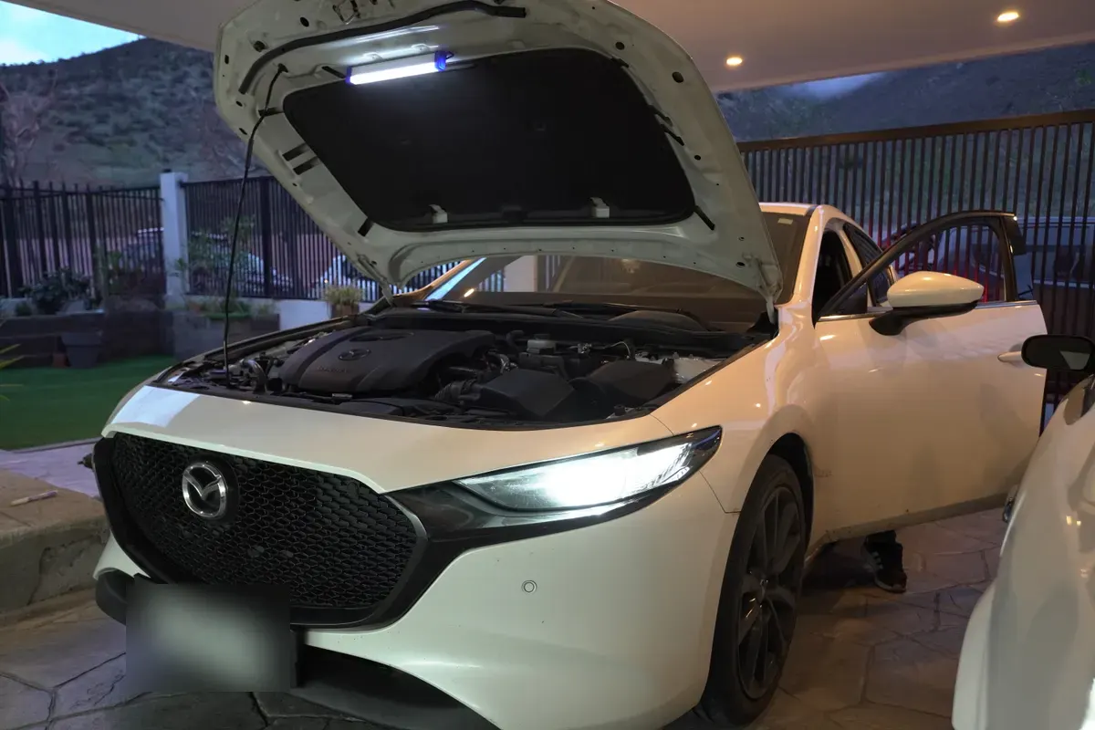 Mazda 3 con el capó abierto durante una mantención preventiva a domicilio en Ciudad de los Valles