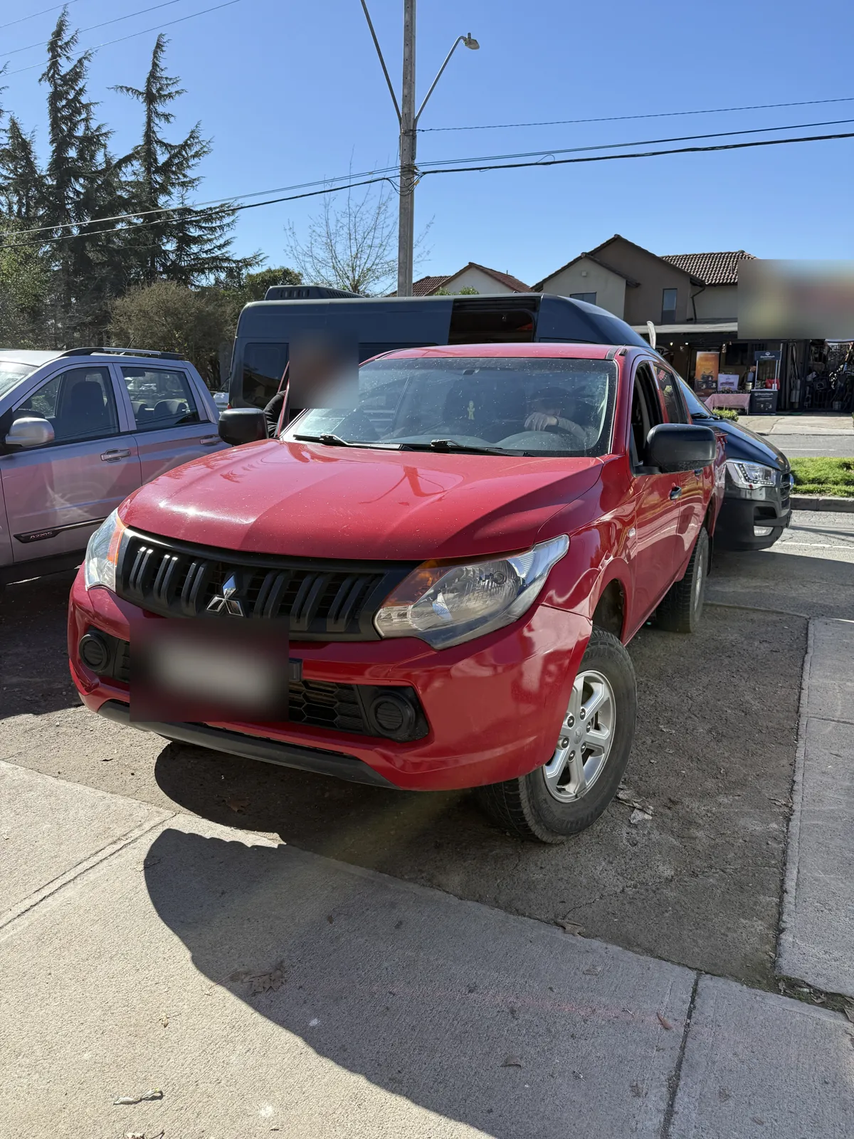 Mitsubishi L200 roja estacionada durante una revisión precompra